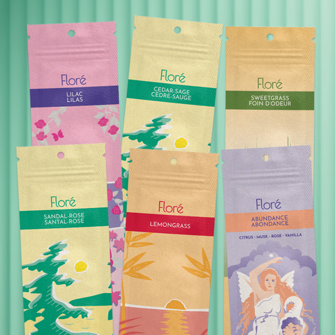 Six different packages of incense sticks lay in two rows against a pale green background. The back row includes Lilac, Cedar-Sage and Sweetgrass, and the front row includes Sandal-Rose, Lemongrass and Abundance.