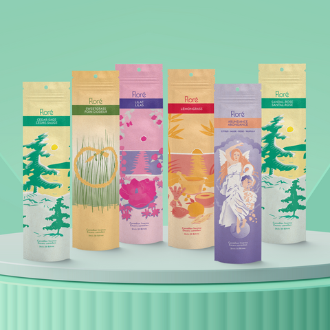 Six different packages of incense sticks standing upright against a pale green background. From left to right the packages include Cedar-Sage, Sweetgrass, Lilac, Lemongrass, Abundance and Sandal-Rose.