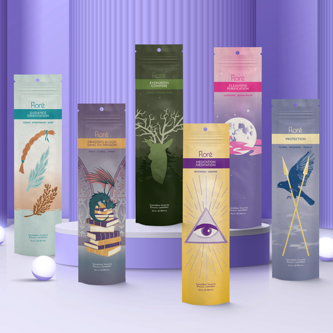 Six different packages of incense sticks standing upright against a purple background. From left to right the packages include Guidance, Dragon’s Blood, Evergreen, Meditation, Cleansing and Protection.