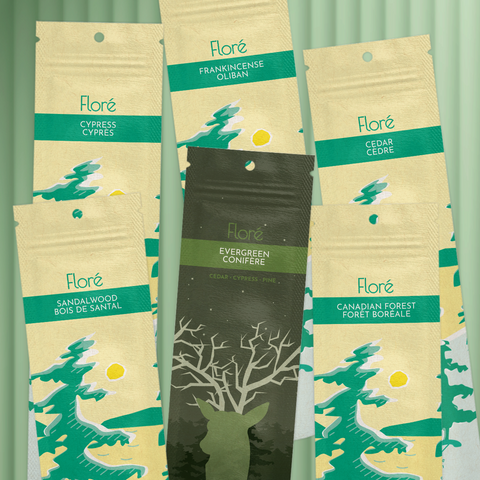 Six different packages of incense sticks lay in two rows against a mossy green background. The back row includes Cypress, Frankincense and Cedar, and the front row includes Sandalwood, Evergreen and Canadian Forest. 