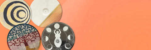 Four circular incense burners featuring a tree of life, gold and spirals, woman and moons, and stone and wood. 