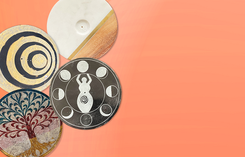 Four circular incense burners featuring a tree of life, gold and spirals, woman and moons, and stone and wood. 