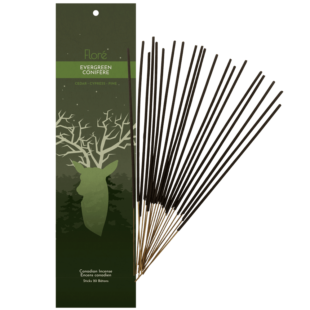 Image of 1 package of Flore Canadian Incense Evergreen fragrance, featuring a deer head with tree branch antlers on dark green forest background with small stars in the sky. There are 20 incense sticks splayed beside it as every package contains 20 incense sticks. Scent notes displayed are cedar, cypress, pine.