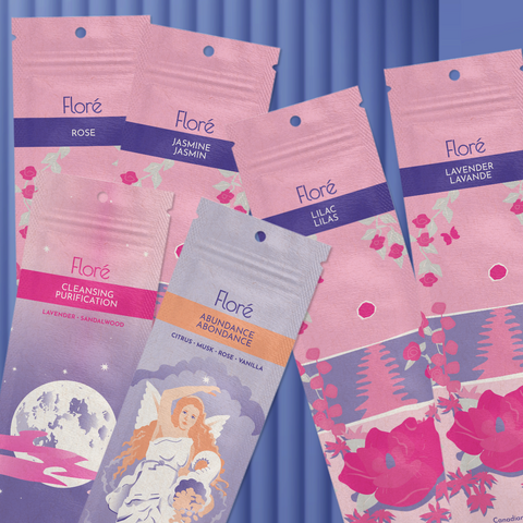 Six different packages of incense sticks lay askew on a pale indigo background. The packages are Abundance, Cleansing, Rose, Jasmine, Lilac and Lavender.