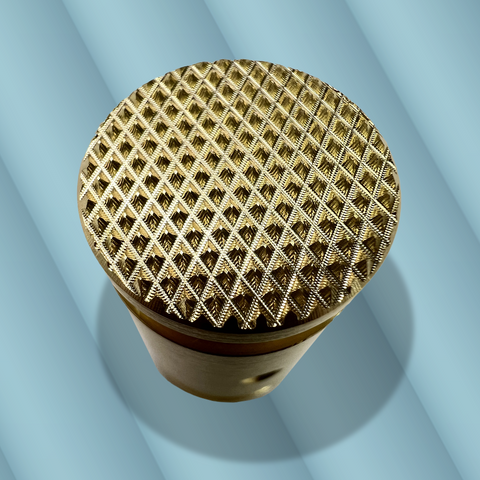 A close up of a brass knob with a detailed cross hatched pattern against a blue-grey background. The knob is a component of a black metal incense burner designed and fabricated by Toronto CNC machine shop Rocket Surgery Solutions, and is used to adjust the angle of an incense stick. 