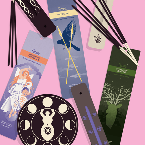 An overhead illustrated view of packages of Abundance incense sticks, Protection incense sticks, and Evergreen incense sticks surrounded by several incense burners and loose incense sticks. 