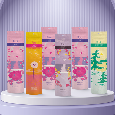 Six different packages of incense sticks standing upright against a golden yellow background. From left to right the packages include Rose, Bliss, Lilac, Spring, Rain and Sandal-Rose. 