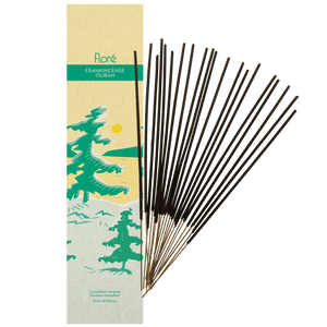 Image of Flore Canadian Incense Frankincense package, featuring green pine trees on a golden lake with a yellow sun. There are 20 incense sticks splayed beside it as every package contains 20 incense sticks. 